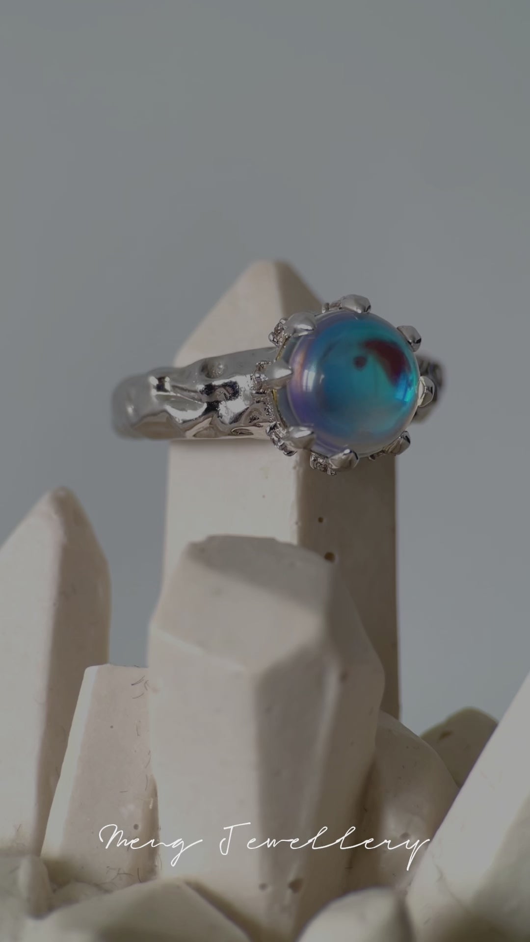 Color-changing opal ring showing iridescent blue tones on adjustable silver band
